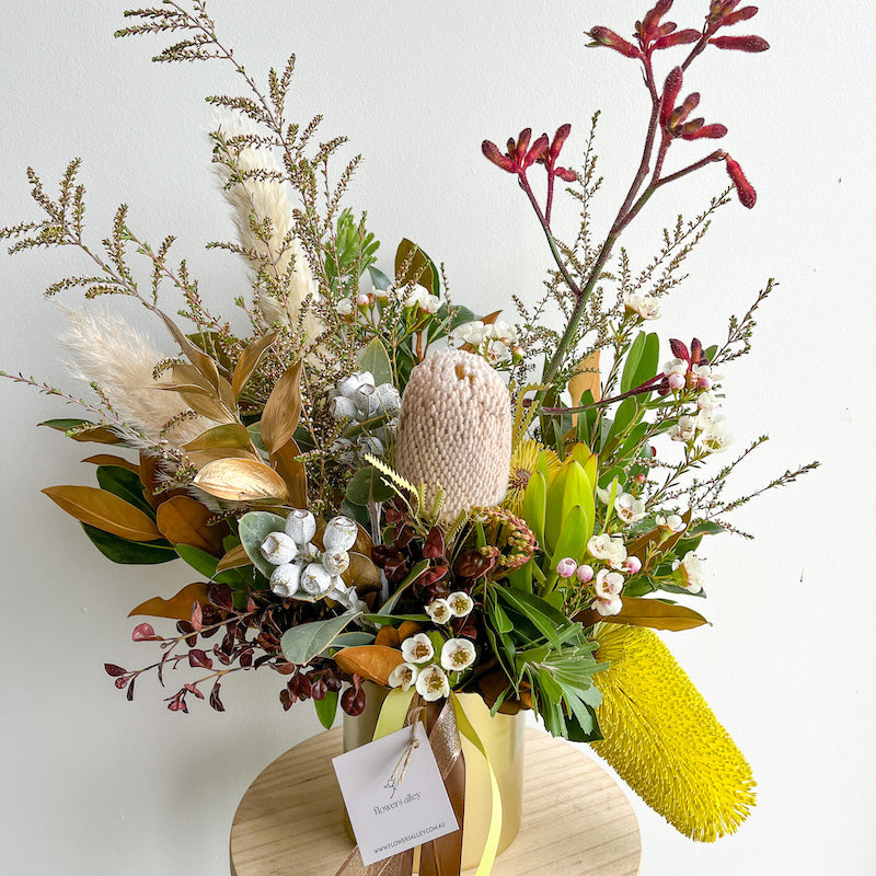 seasonal native flowers in a gold vase